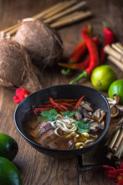 Ahşap masa üzerinde siyah kase Vietnamca Pho çorbası
