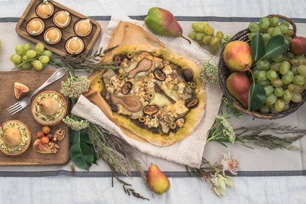 bahçede şenlikli masaya pizza, kek, tartlets armut ve meyve ile Üstten Görünüm