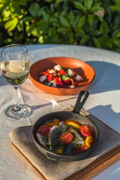 Makarna salatası ve beyaz şarap ile Bahçe tabloda tavada kızarmış balık