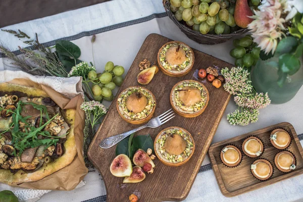 bahçede şenlikli masaya pizza, kek, meyve ve tartlets ile armut Üstten Görünüm