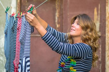 Genç kadın kırsal evin önünde ip açık havada çamaşır asılı