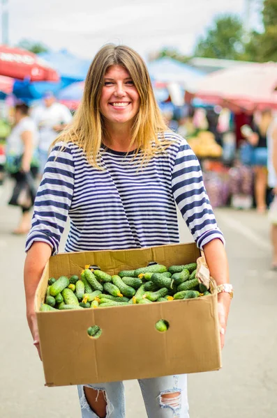 Uśmiechnięta Kobieta Trzyma Skrzynkę Świeżych Ogórków Rynku Rolników — Zdjęcie stockowe