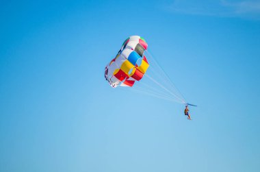 Açık mavi gökyüzünde parasailing insanlar
