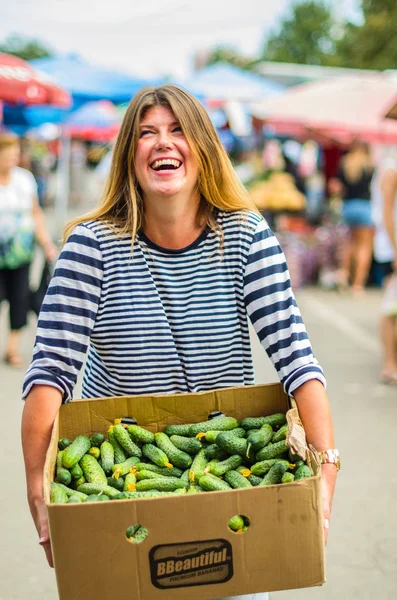 Uśmiechnięta Kobieta Trzyma Skrzynkę Świeżych Ogórków Rynku Rolników — Zdjęcie stockowe