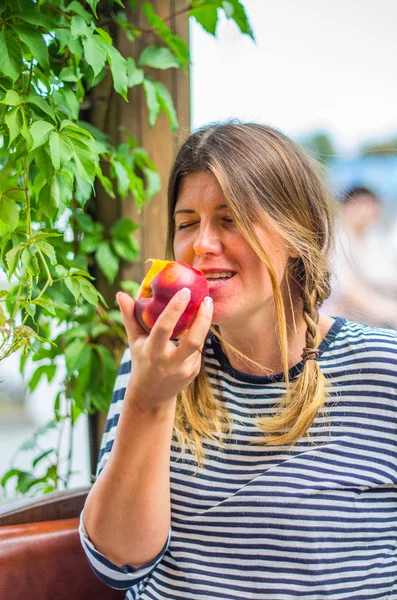 Bütün taze şeftali yeme sevimli kadın portresi