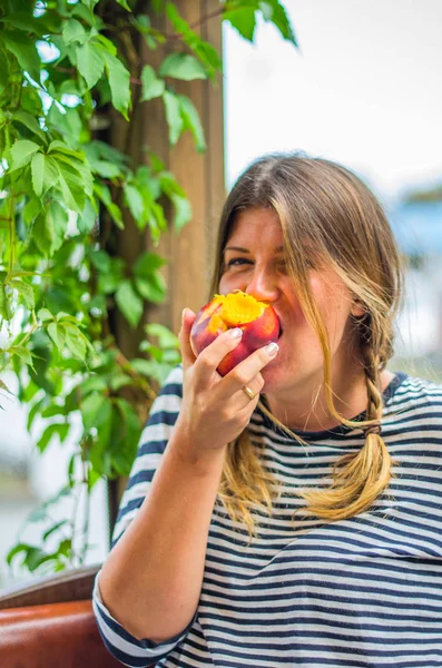 Bütün taze şeftali yeme sevimli kadın portresi