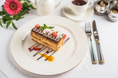 lezzetli kek çilek ve nane plaka, çatal bıçak ve çay ile yakından görmek tablo