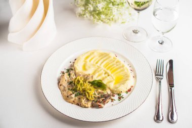 Krem sos mantar ile patates püresi restoranda beyaz masada plaka üzerinde hizmet