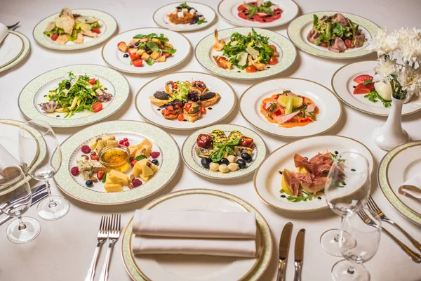 Mesa Restaurante Con Muchos Platos Diferentes Placas Tenedores Cuchillos Vasos —  Fotos de Stock