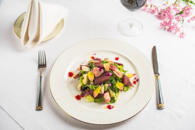 parma jambonu ve yenilebilir çiçekler ile lezzetli yemek tabağı, kadeh şarap ve çatal bıçak Restoran tablo ile görmek