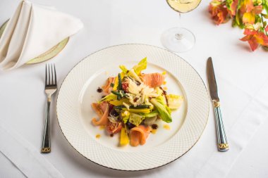 Masada beyaz tabakta somon taze sebze salatası