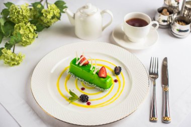 Yeşil tatlı çilek ile yakından görmek tabak ve bardak çay tablo