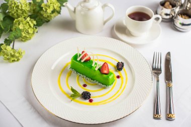 Yeşil tatlı çilek ile yakından görmek tabak ve bardak çay tablo