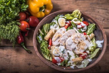 ahşap masa ıslak zeminde Sezar salata servis