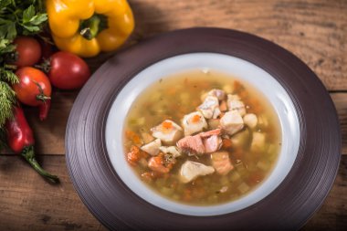 Ev yapımı tavuk çorbası malzemeler ile ahşap masa tabakta servis