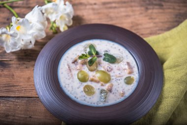 Ahşap masa çiçekli tabakta çorba balık krem