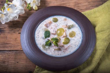 Ahşap masa çiçekli tabakta çorba balık krem