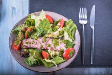 Çatal bıçak takımı peçeteyle kase dilimlenmiş etli taze sebze salatası
