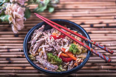 Asya erişte bambu hasır üzerinde yemek çubukları ile kasede servis