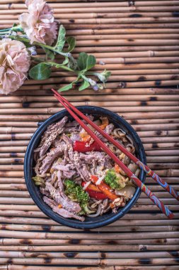 Asya erişte bambu hasır üzerinde yemek çubukları ile kasede servis