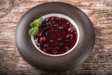 Ahşap masa üzerine nane yaprakları ile tabakta kiraz jöle