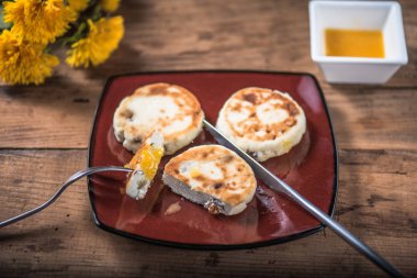 Ahşap masa çiçekli tabakta üzerine kızarmış peynir börek