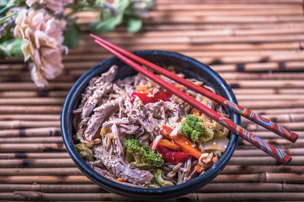 Asya erişte bambu hasır üzerinde yemek çubukları ile kasede servis