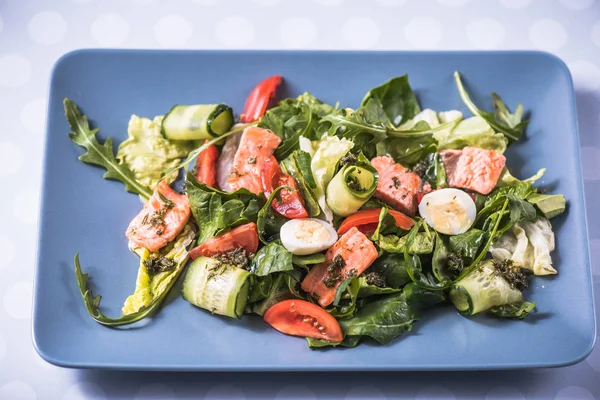 Taze sebze salatası somon ve mavi tabakta Yumurta