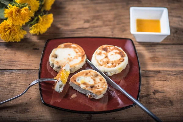 Ahşap masa çiçekli tabakta üzerine kızarmış peynir börek