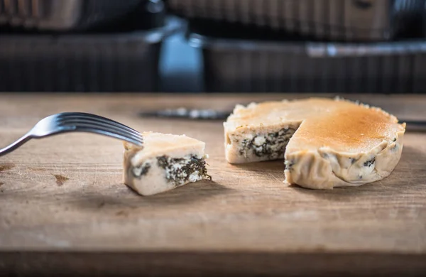 Salty stuffed cake with spinach and cheese on wooden board