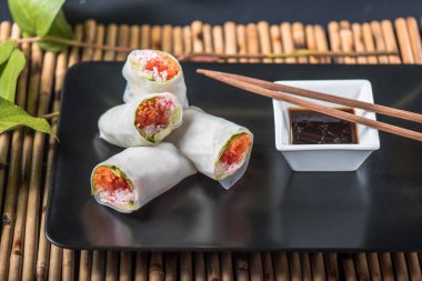 Sebze böreği siyah plaka üzerinde soya sos ile