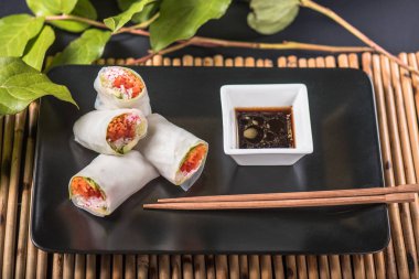 Sebze böreği siyah plaka üzerinde soya sos ile