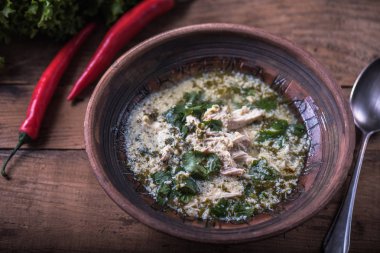 Ahşap masa üzerinde bir kapta tavuk ve sebze çorbası