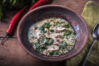 Ahşap masa üzerinde bir kapta tavuk ve sebze çorbası