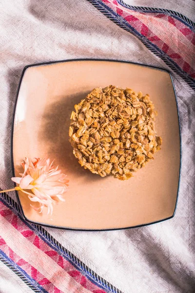 Healthy oatmeal cake served on pink plate with flower on fabric