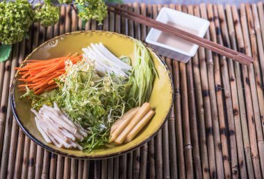 Kase üzerinde bambu peçete soslu taze sebze çizgili