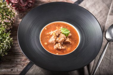 Ahşap masa üzerinde siyah plaka servis etli domates çorbası