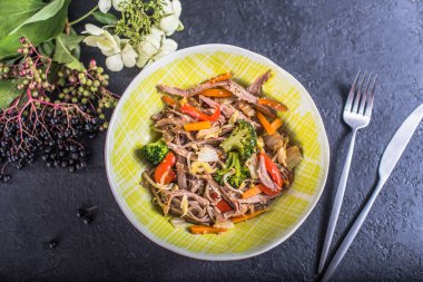 Et ve çiçeklerle tabakta sebze erişte