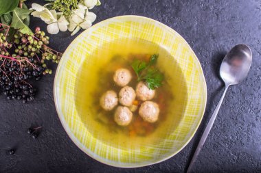 Siyah yüzeyi sarı kase çorba köfte ile hizmet