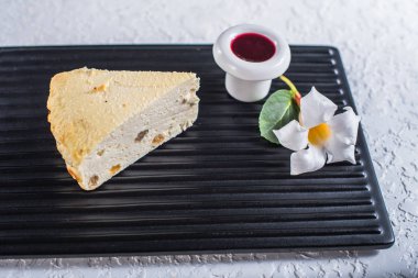 Parçası cheesecake çiçek ile kara tahta üzerinde reçelli