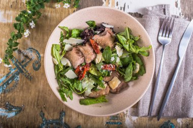 eski püskü ahşap masa üzerinde bir kapta tavuk ile sebze salatası