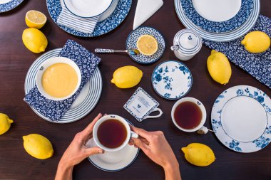 insan elleri masada limon lor ile çay fincan tutan