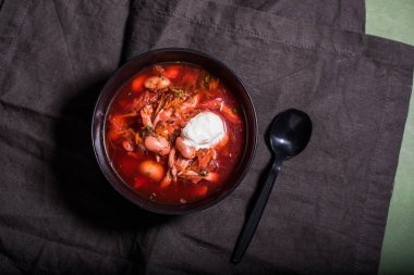 Ev yapımı Borsch siyah kase plastik kaşık ile masa örtüsü üzerinde hizmet