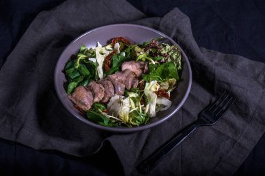 Ördek siyah kumaş üzerine kase taze sebze salatası