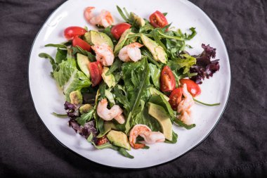 Deniz ürünleri sebze salatası masa örtüsü tabakta servis