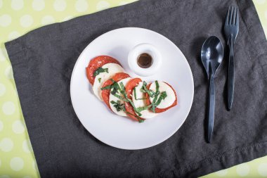 Caprese peçete üzerinde beyaz tabakta sebze salatası