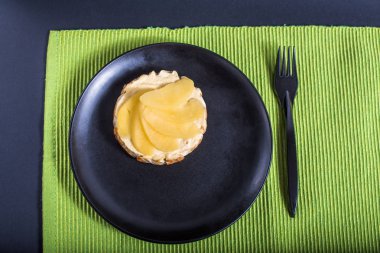 Yeşil peçete üzerinde siyah plaka üzerinde meyve ile ev yapımı kek