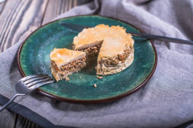 lezzetli pişmiş buğday pasta tabak ve çatal bıçak üzerinde ahşap masa masa örtüsü ile görmek