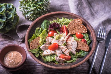 Tavuk ve kruton ahşap masa üzerinde kase sebze salatası