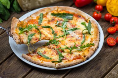 parmesan peynir, roka ve domates gurme pizza ahşap masa üzerinde görmek